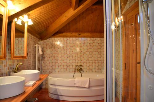 a bathroom with two sinks and a bath tub at Villa Ferrera Posada Rural in Herrera de Valdecañas