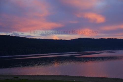 a sunset over a body of water at Bakarloko Lipno Apartments in Lipno nad Vltavou