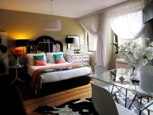 a bedroom with a bed and a glass table at The Gallery Studios in Porto