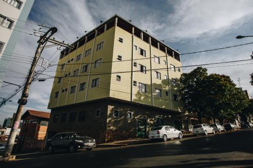 ein hohes Gebäude mit davor geparkt in der Unterkunft Hotel JB in Bom Despacho