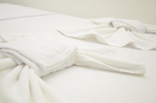 a white blanket laying on top of a bed at Hotel Icamiabas in Parintins