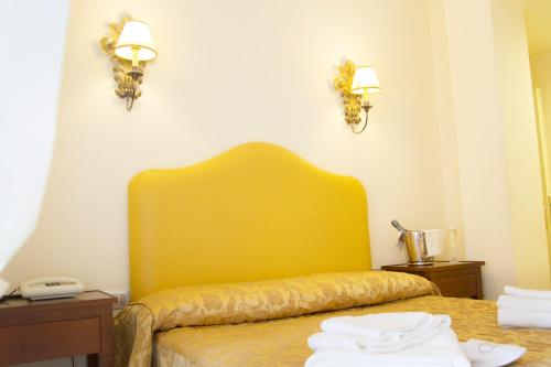 a hotel room with a yellow bed with towels on it at Hotel Lanzillotta in Alberobello