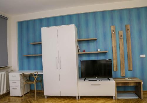 a white cabinet with a tv and a desk at Apartments Parlament in Belgrade