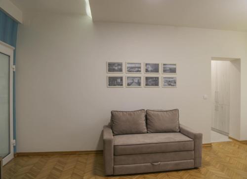 a couch sitting in a room with a white wall at Apartments Parlament in Belgrade