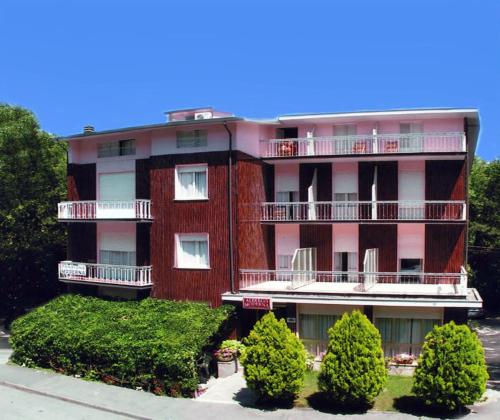 un bâtiment rouge avec des arbres devant lui dans l'établissement Albergo Moderna, à Tabiano