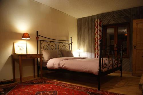 a bedroom with a bed and a table with a lamp at Gîte du Thalala in Bernardvillé