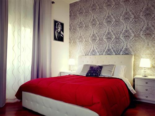 um quarto com uma cama grande e um cobertor vermelho em Lido di Ostia 1933 em Lido di Ostia
