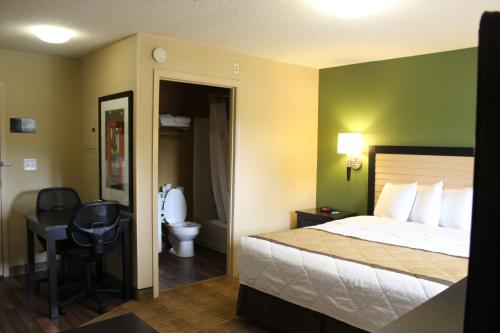 a hotel room with a bed and a desk and a toilet at Extended Stay America Suites - Chesapeake - Greenbrier Circle in Chesapeake