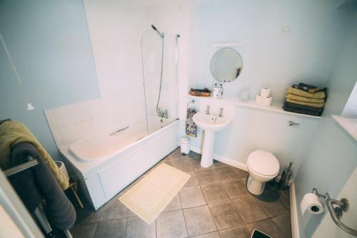 uma casa de banho com um lavatório e um WC. em City centre penthouse apartment em Belfast