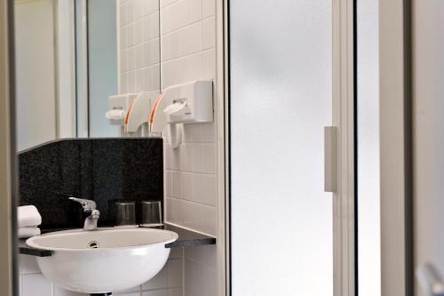 a bathroom with a sink and a mirror at TRYP by Wyndham Halle in Halle an der Saale