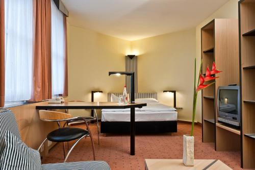 a hotel room with a bed and a desk at TRYP by Wyndham Halle in Halle an der Saale