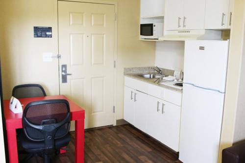 a small kitchen with a red desk and a white refrigerator at Extended Stay America Suites - Chesapeake - Greenbrier Circle in Chesapeake