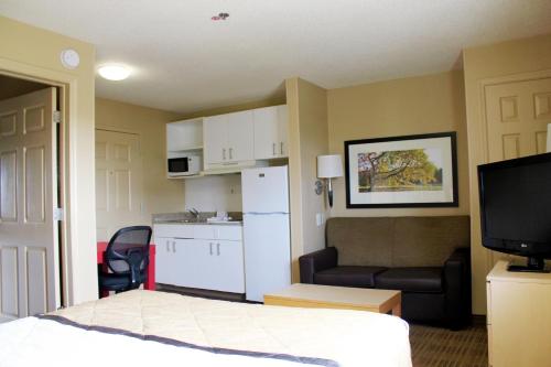 a hotel room with a bed and a kitchen and a television at Extended Stay America Suites - Chesapeake - Greenbrier Circle in Chesapeake