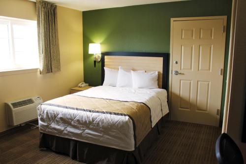 a hotel room with a bed and a door at Extended Stay America Suites - Chesapeake - Greenbrier Circle in Chesapeake