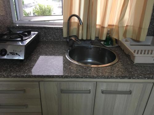 a kitchen counter with a sink and a window at Br Court Apartments in Quatre Bornes