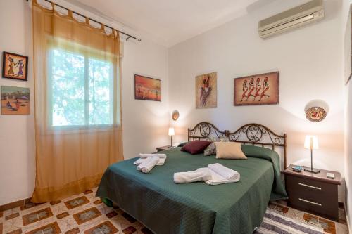 ein Schlafzimmer mit einem grünen Bett und Handtüchern darauf in der Unterkunft Villa Violetta in Carini