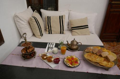 stół śniadaniowy z jedzeniem i napojami na łóżku w obiekcie Riad Azza w Marakeszu