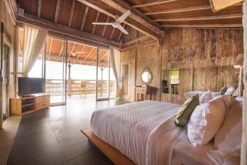 een slaapkamer met een bed en een televisie. bij Bella Kita Mountain Retreat & Spa in Klungkung