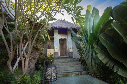 a small house with stairs leading up to a porch at Bella Kita Mountain Retreat & Spa in Klungkung
