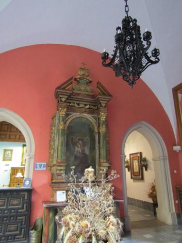 a room with a painting on the wall and a chandelier at Hospederia del Real Monasterio in Guadalupe