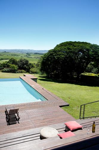 a wooden deck next to a swimming pool at Ongoye View Residence - Mtunzini in Mtunzini