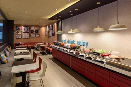 a restaurant with a buffet line with tables and chairs at ibis Sao Bernardo do Campo in São Bernardo do Campo