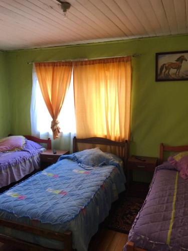 a bedroom with two beds and a window at Hospedaje Freire in Osorno