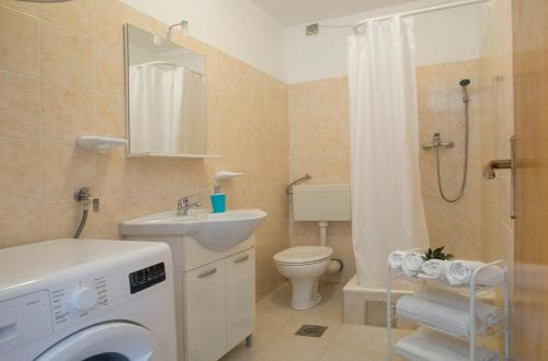 a bathroom with a toilet sink and a washing machine at Great Located Family Apartments in Marina