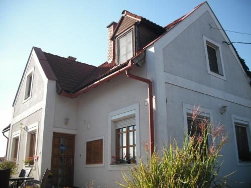 a white house with a window and a roof at Viktória Inn Tihany in Tihany