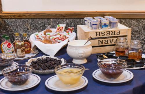 a table topped with bowls of food and drinks at Hotel Ristorante La Perla in Varallo Pombia