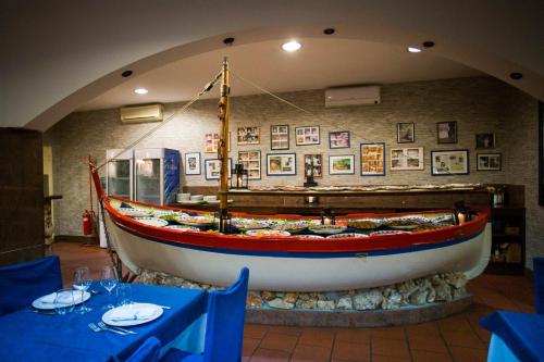 a large boat on display in a restaurant at Hotel Ristorante La Perla in Varallo Pombia