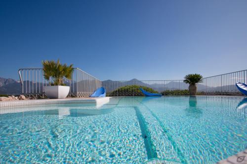 a large swimming pool with blue chairs in it at Verdeluna ApartHotel in Marina di Pietrasanta