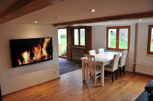 a dining room with a table and a fireplace at Echtes Schwarzwaldhaus - Traditionell & Modern in Bernau im Schwarzwald