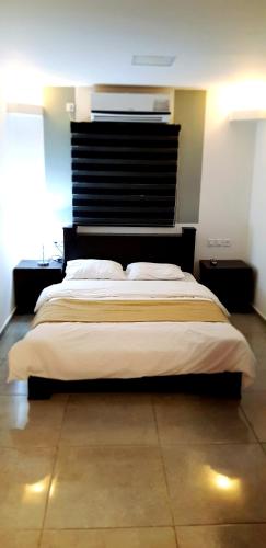 a bedroom with a large bed with a black headboard at City Apartments in Eilat