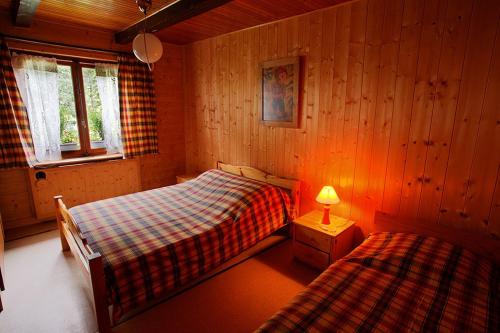a bedroom with two beds and a lamp in it at Les Allamands in Morzine