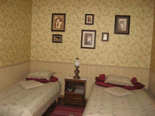 two beds in a bedroom with pictures on the wall at Kalbuse House in Treimani