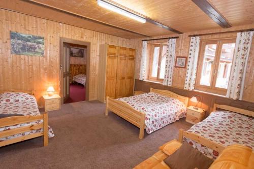 um quarto com 2 camas e 2 janelas em Maison de la coutetta em Morzine