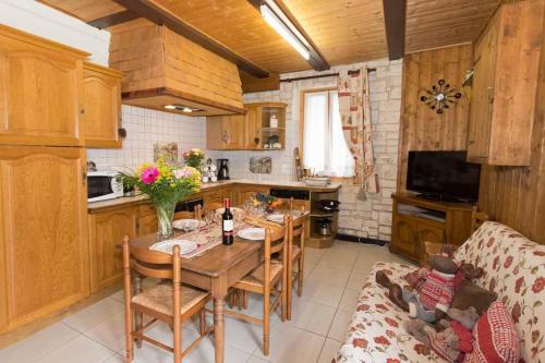 uma cozinha e sala de jantar com mesa e cadeiras em Maison de la coutetta em Morzine