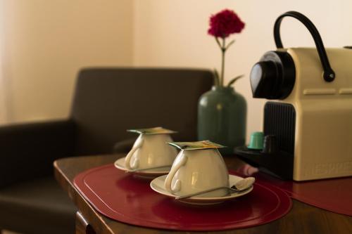 a table with two tea cups and a toaster at Finna Hótel in Hólmavík