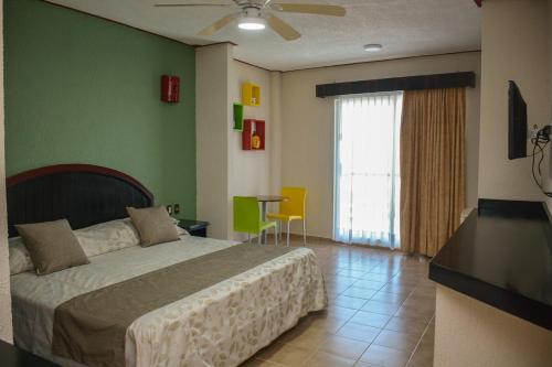 a bedroom with a bed and a table and a window at Suites Los Arcos in Isla Mujeres