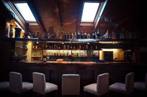 a bar with a bunch of bottles and chairs at Hotel Ristorante La Perla in Varallo Pombia