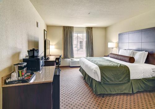 Habitación de hotel con cama y TV en Cobblestone Inn & Suites - Big Lake, en Big Lake