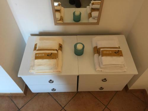 een kleine witte kast met handdoeken en een spiegel bij Gallery Bellini Apartment in Napels