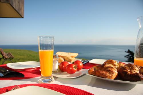 una mesa con un plato de comida y un vaso de zumo de naranja en Agroturismo Haitzalde B&B - Adults Only, en Mutriku