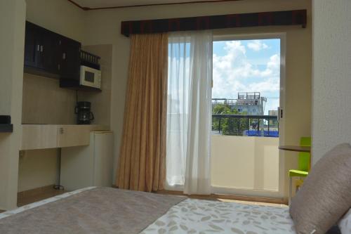 a bedroom with a large glass door with a balcony at Suites Los Arcos in Isla Mujeres