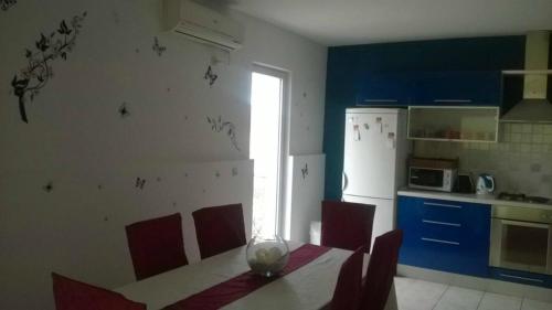a kitchen with a table with chairs and a refrigerator at Apartment Roksy in Supetar