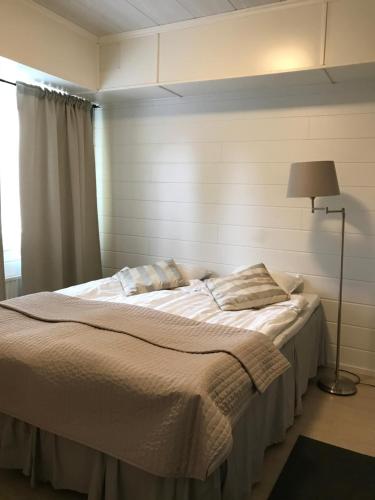 トルニオにあるE-City B&Bのランプとベッドサイドシックスが備わる客室の大型ベッド1台分です。