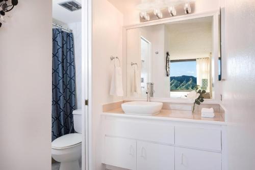 a white bathroom with a sink and a mirror at Waikiki Banyan 3411 Ocean View - FREE PARKING in Honolulu