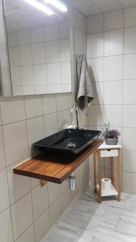 bagno con lavandino nero e specchio di Spinola Seafront Apartment a San Giuliano