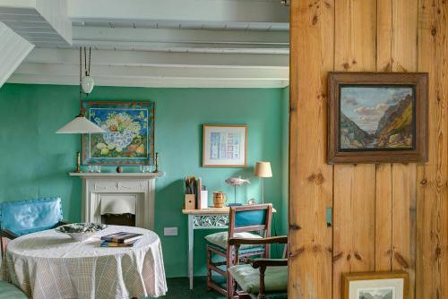 a green room with a table and a desk at Aberdaron Cottage 2 Bryn Chwilog in Aberdaron